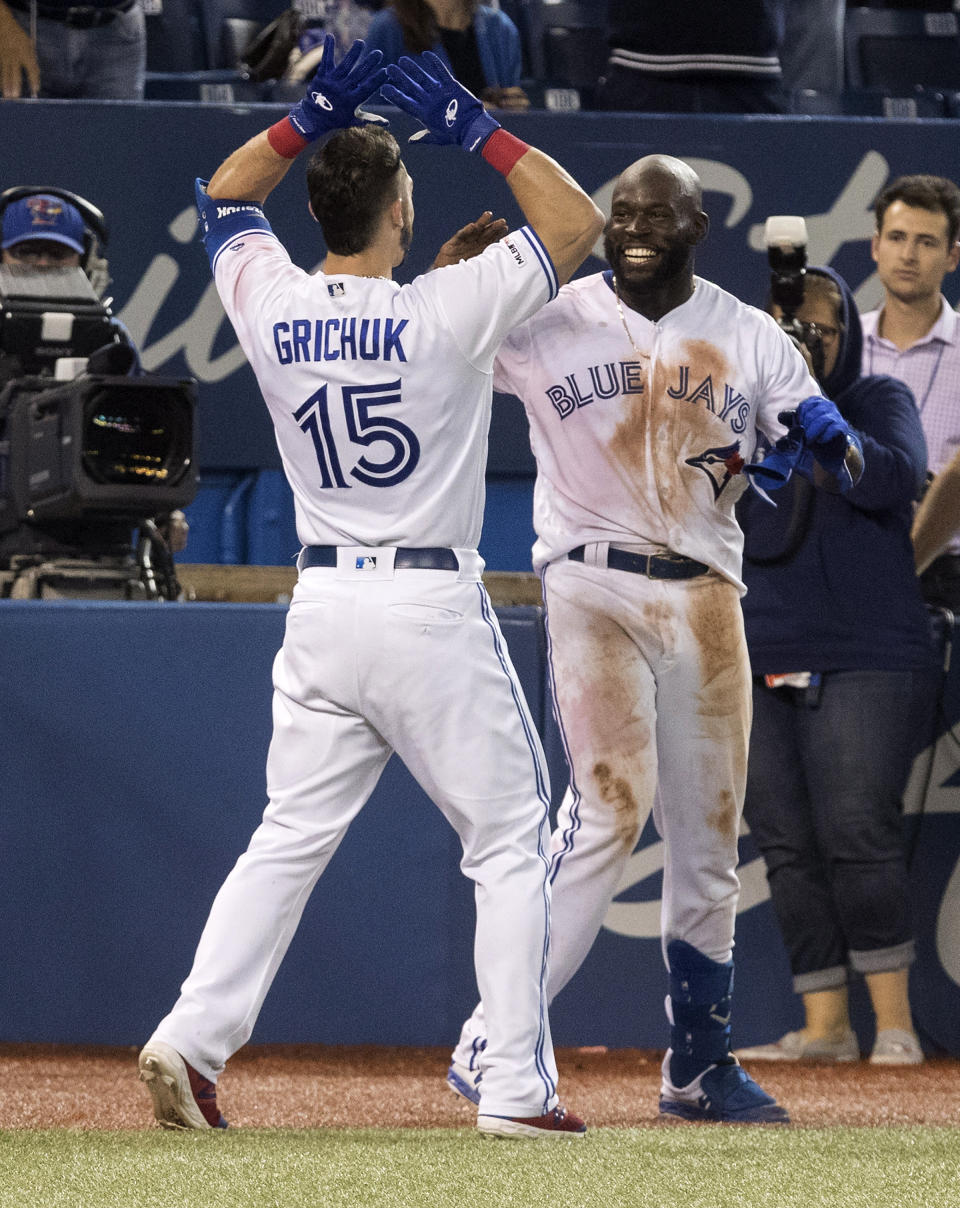 Toronto Blue Jays' Anthony Alford celebrates his walk-off home run with teammate Randal Grichuk to end the ballgame in the 15th inning against the Baltimore Orioles, Monday, Sept. 23, 2019, in Toronto. Toronto won 11-10. (Fred Thornhill/The Canadian Press via AP)