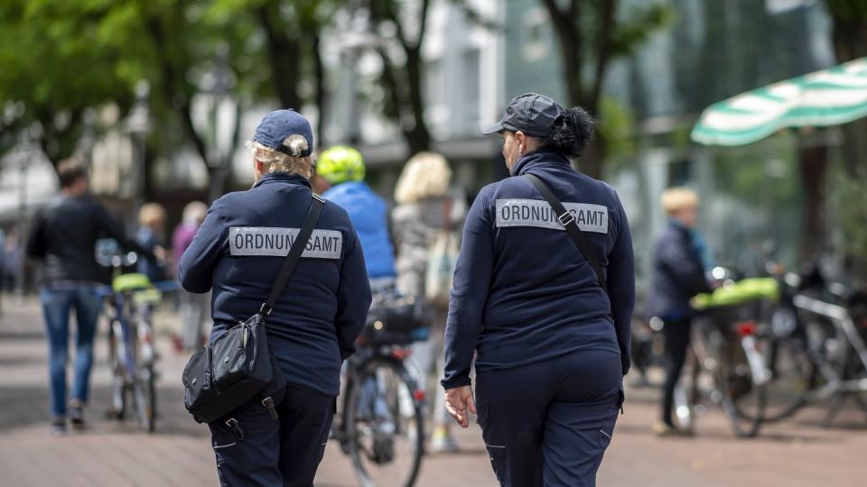 Zwei Mitarbeiterinnen vom Ordnungsamt kontrollieren in der Berliner Straße in der Innenstadt von Güterloh.