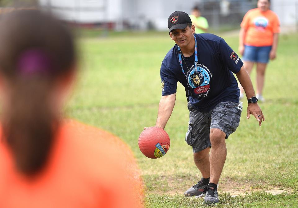 Erie police Lt. Tom Lenox plays kickball with kids during the Erie Police Athletic League summer program July 13, 2020, at the Boys & Girls Club of Erie. Recreational kickball for adults has grown locally in recent years.