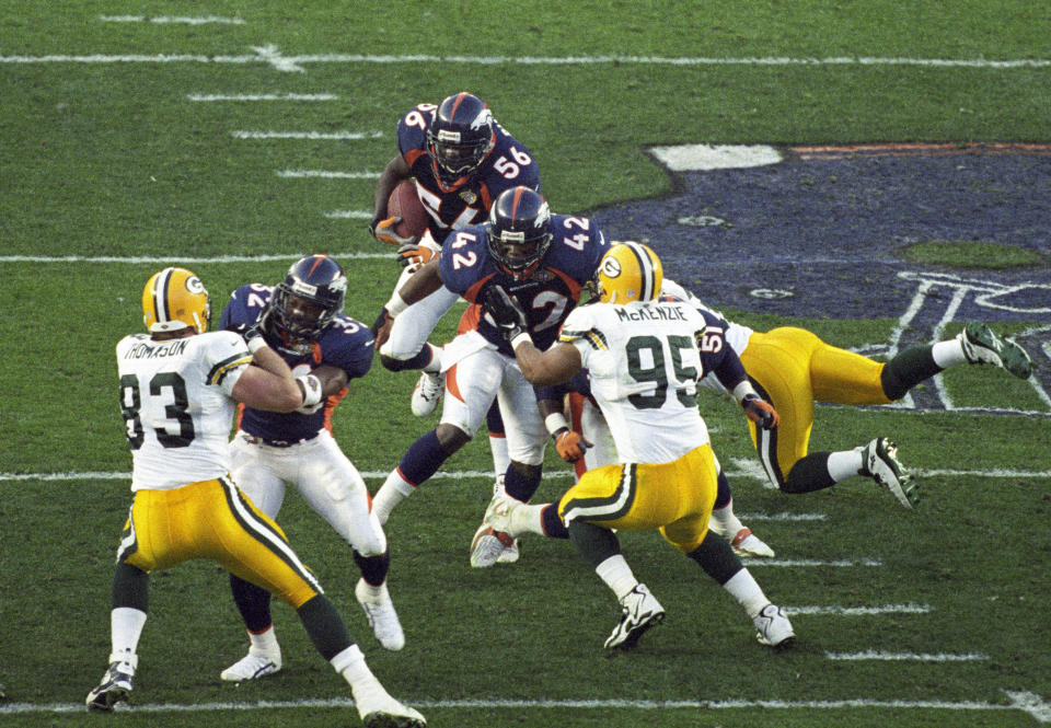 Jan 25, 1998; San Diego, CA, USA; FILE PHOTO; Denver Broncos kick returner Keith Burns (56) carries the ball as Tony Veland (32) and Detron Smith (42) block against Green Bay Packers defensive end Keith McKenzie (95) and Jeff Thomason (85) during Super Bowl XXXII at Qualcomm Stadium. The Broncos defeated the Packers 31-24. Mandatory Credit: Peter Brouillet-USA TODAY Sports