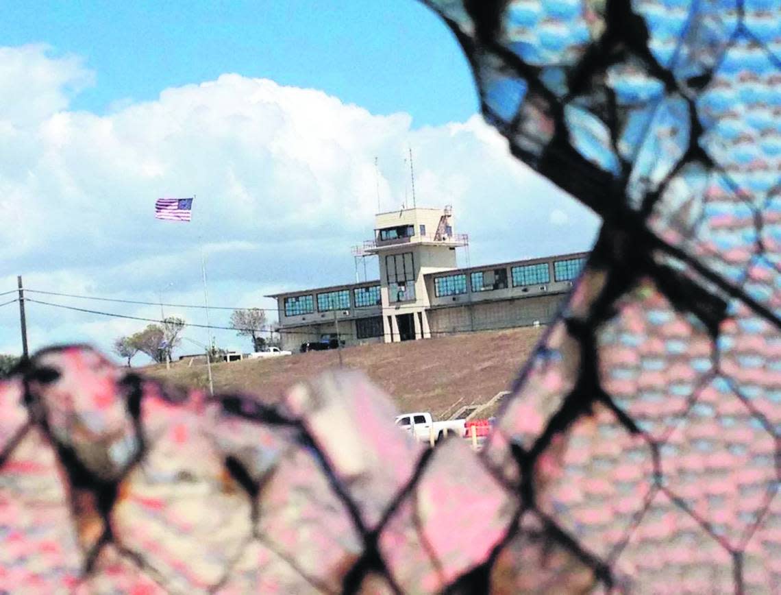 The war court headquarters at Camp Justice, at Guantánamo Bay, Cuba, seen through a broken window at an obsolete air hangar at the U.S. Navy base at Guantánamo Bay, Cuba.