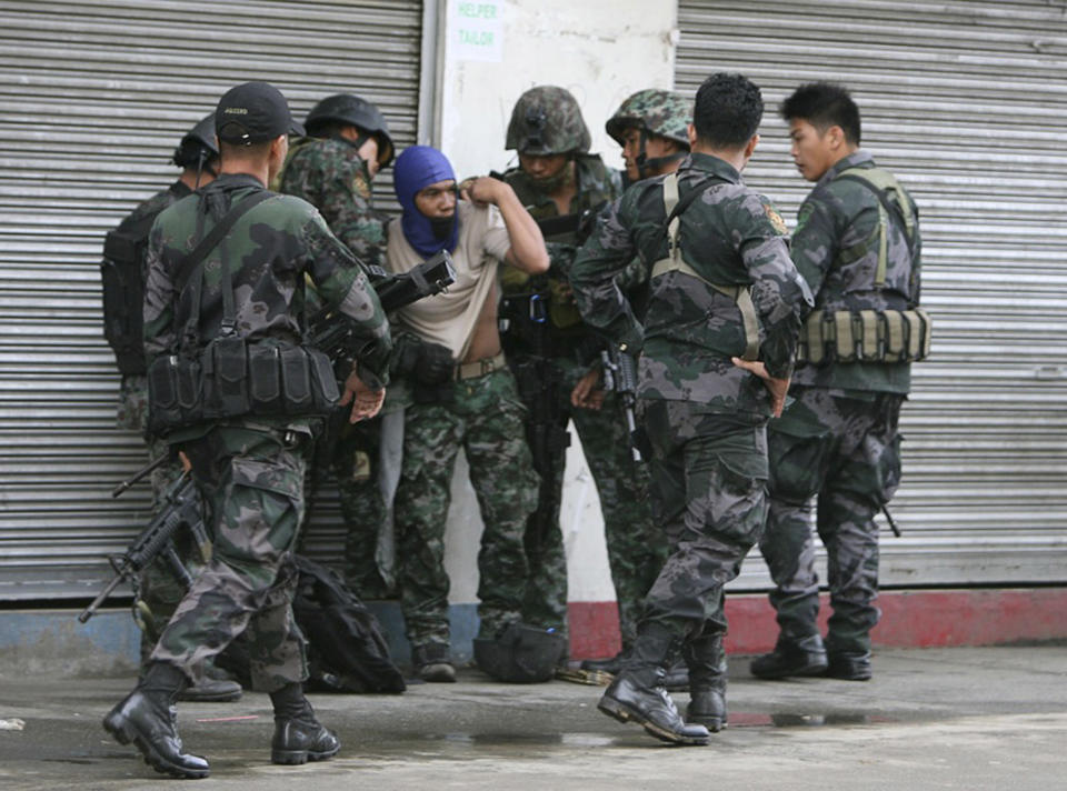 Combat police forces check their comrade who was hit by sniper fire of the MNLF during an encounter in downtown Zamboanga City