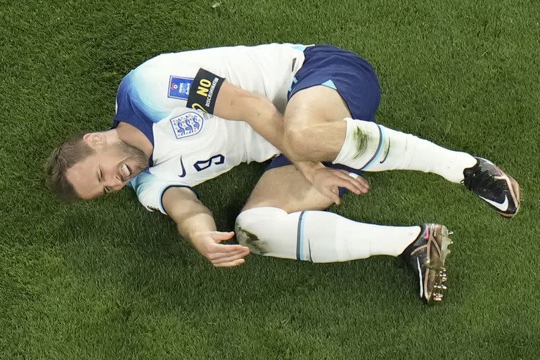 El inglés Harry Kane hace un gesto de dolor tras recibir un golpe del iraní Morteza Pouraliganji en un juego del Grupo B del Mundial que enfrentó a ambos equipos, en el estadio Jalifa Internacional, en Doha, Qatar, el 21 de noviembre de 2022. (AP Foto/Hassan Ammar)