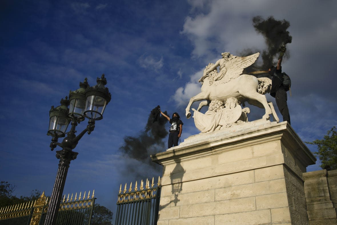 Youth light flares on Concorde square during a protest in Paris, France, Friday, June 30, 2023. (AP Photo/Lewis Joly)