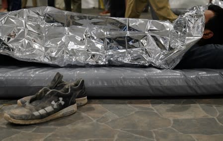 An asylum-seeker rests at the Donna Soft-Sided Processing Facility in Donna, Texas