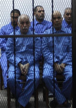 Former prime minister Baghdadi al-Mahmoudi (L) and Mohamed Belkacem Zwei, former Secretary General of the General People's Congress, sit behind bars during a hearing at a courtroom in Tripoli April 14, 2014. REUTERS/Ismail Zitouny