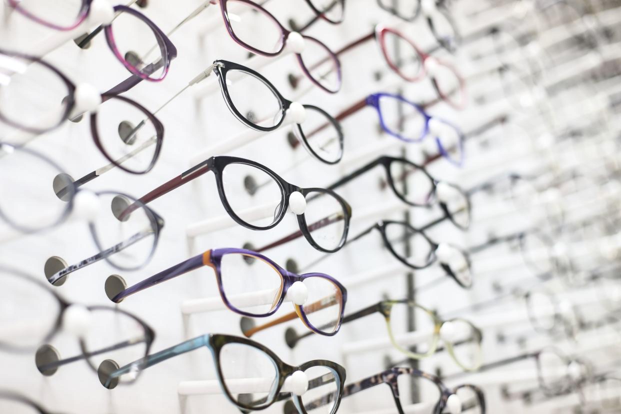 Large group of eyeglasses in an eyewear store display.