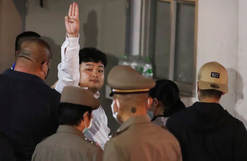 Parit Chiwarak is escorted after being arrested at the police station in Bangkok