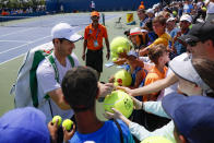 Andy Murray, left, of Britain, signs autographs after practicing at the Western & Southern Open tennis tournament, Sunday, Sunday, Aug. 11, 2019, in Mason, Ohio. (AP Photo/John Minchillo)
