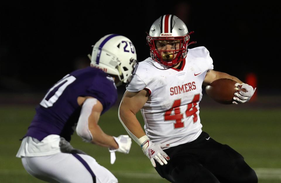 Somers Jack Kaiser (44) tries to get around John Jay's Julian Koronowski (20) during the Class A bowl championship at John Jay High School in Cross River April 23, 2021. Somers won the game 17-14.