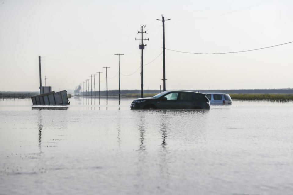 Vehicles are submerged in floodwaters.