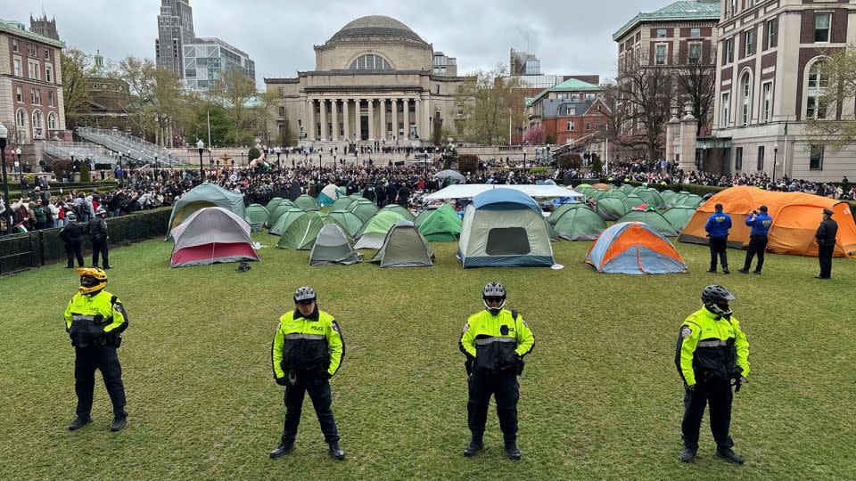 Police officers stand near tents erected by pro-Palestinian protesters on the South Lawn at Columbia University in New York, on Thursday. - C.S. MUNCY/The New York Times/Redux