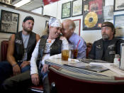 Mientras Obama era abrazado y levantado por un pizzero forzudo, su vicepresidente Joseph Biden se hacía fotos de esta guisa con un grupo de moteros en otro restaurante. Todo sea por ganar unos votos. (AP Photo/Carolyn Kaster)