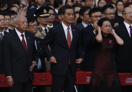 Hong Kong Chief Executive Leung Chun-ying (C), his wife Regina, and former Hong Kong Chief Executive Tung Chee-hwa (L) attend a flag raising ceremony in Hong Kong October 1, 2014, celebrating the 65th anniversary of China National Day. REUTERS/Bobby Yip