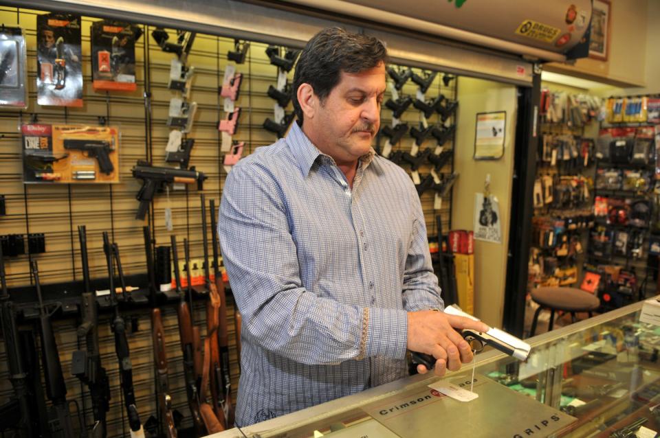 General Manager David Epstein shows a gun to a customer at Welsh Pawn Shop.