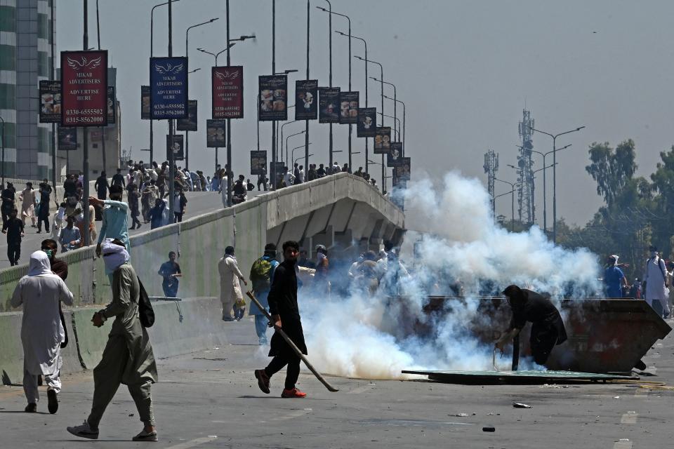 Pakistan Tehreek-e-Insaf (PTI) party activists and supporters of former Pakistan's Prime Minister Imran Khan, clash with police during a protest against the arrest of their leader in Peshawar on May 10, 2023.