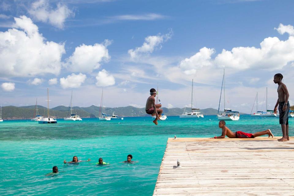 Kids jump from the pier at Jost Van Dyke