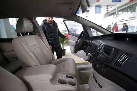 A customer checks a BYD e6 electric car at a dealership in Beijing, China, December 9, 2015. REUTERS/Jason Lee