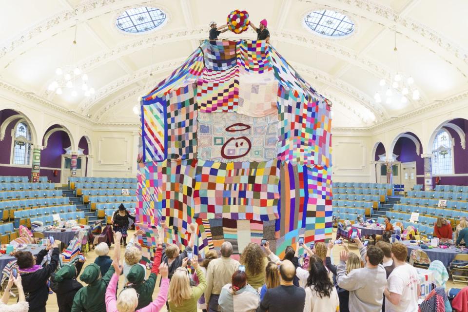 People watch as workers place a giant bobble on top of a 23ft high bobble hat (Dominic Lipinski/PA) (PA Wire)