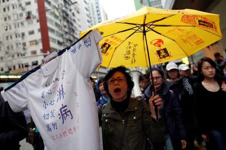 A protester holds up a yellow umbrella, the symbol of the Occupy Central movement, as she marches to demand universal suffrage in the Chief Executive election in Hong Kong, China March 25, 2017. REUTERS/Tyrone Siu