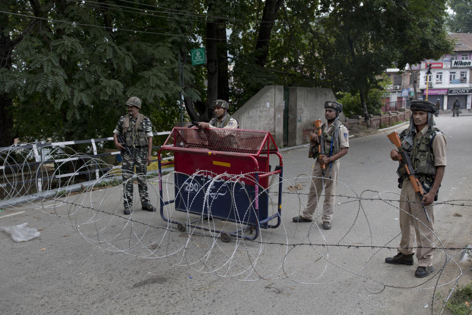 In this Tuesday, Aug. 6, 2019, photo, Indian Paramilitary soldiers stand guard near a temporary barbwire check post set up on a bridge during curfew in Srinagar, Indian controlled Kashmir. Indian Prime Minister Narendra Modi’s vision of a Hindu India took a leap forward with his government’s decision to subsume Kashmir into the federal government by eliminating its special status and allowing anyone to buy property and move into the state, raising fears among residents that they will lose their distinct identity. Indian security forces have arrested more than 500 people since New Delhi imposed a communications blackout and security clampdown in divided Kashmir, where people remained holed up in their homes for a fourth day. (AP Photo/ Dar Yasin)