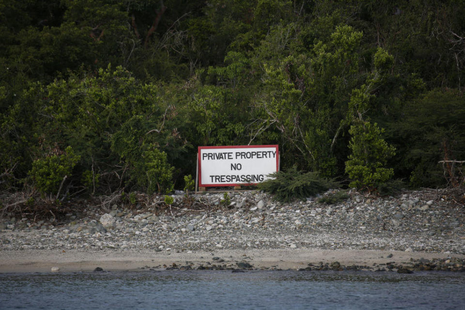 A private property sign is displayed on Little St. James Island, owned by fund manager Jeffrey Epstein, in St. Thomas, U.S. Virgin Islands, on Wednesday, July 10, 2019. This is where Epstein - convicted of sex crimes a decade ago in Florida and now charged in New York with trafficking girls as young as 14 - repaired, his escape from the toil of cultivating the rich and powerful.  / Credit: Marco Bello/Bloomberg via Getty Images