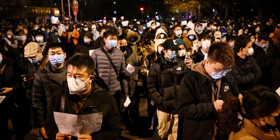 Protesters march along a street during a rally for the victims of a deadly fire as well as a protest against China's harsh Covid-19 restrictions in Beijing on November 28, 2022.