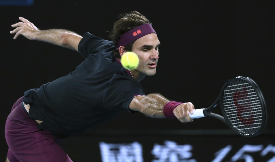 Switzerland's Roger Federer makes a backhand return to Serbia's Filip Krajinovic during their second round singles match at the Australian Open tennis championship in Melbourne, Australia, Wednesday, Jan. 22, 2020. (AP Photo/Dita Alangkara)