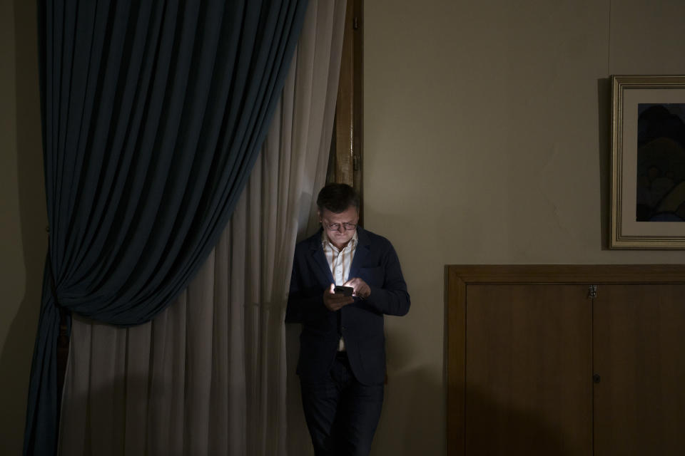Ukraine's Foreign Minister Dmytro Kuleba uses his phone before an interview with The Associated Press in Kyiv, Ukraine, Monday, Dec. 26, 2022. (AP Photo/Felipe Dana)