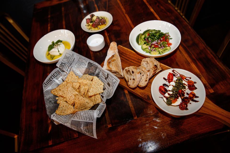 Tapas ranging from guacamole and chips, to steak skewers to burrata to Caprese salad sit on display at American Barrel in Columbia, Tenn. on Apr. 20, 2023.