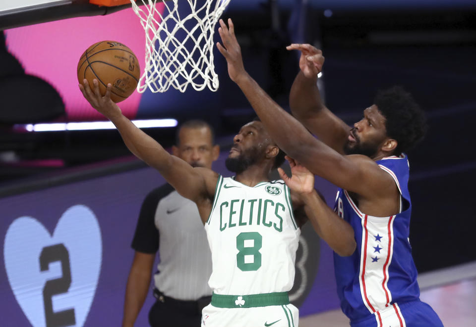 Boston Celtics guard Kemba Walker (8) shoots past Philadelphia 76ers center Joel Embiid, right, during the first quarter of Game 4 of an NBA basketball first-round playoff series, Sunday, Aug. 23, 2020, in Lake Buena Vista, Fla. (Kim Klement/Pool Photo via AP)