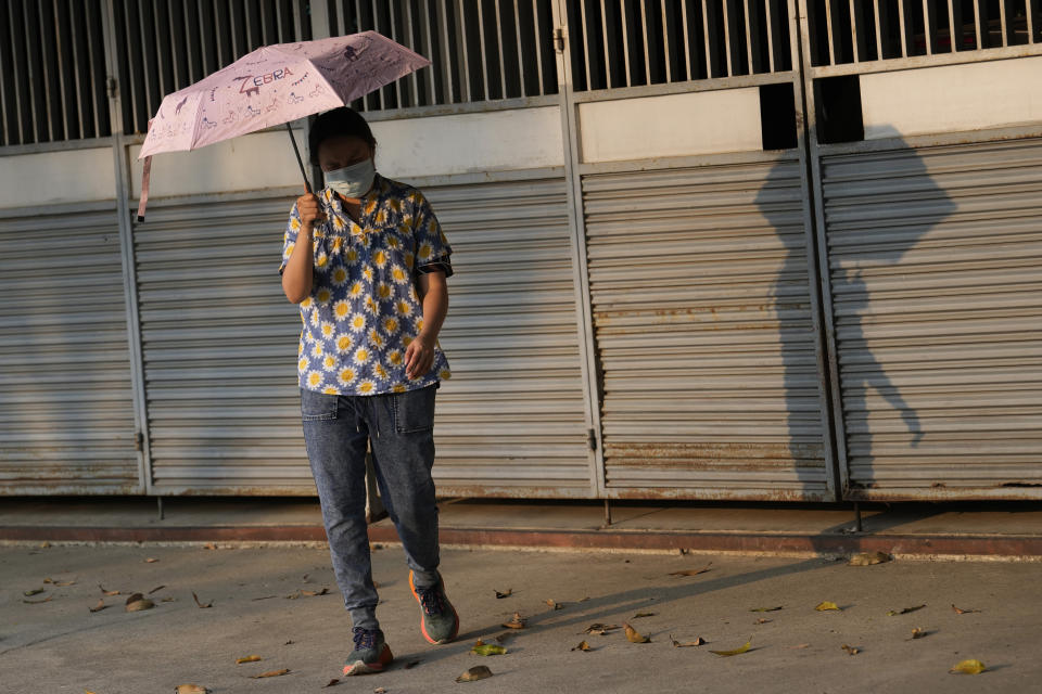 FILE - A woman holds an umbrella to shelter from the sun in Bangkok, Thailand, April 22, 2023. A searing heat wave in parts of southern Asia in April this year was made at least 30 times more likely by climate change, according to a rapid study by international scientists released Wednesday, May 17. (AP Photo/Sakchai Lalit, File)