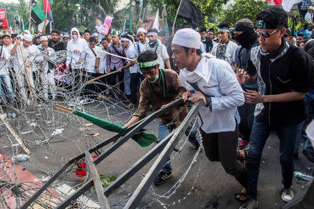 Muslim students brokes the barb wire during a protest against Jakarta's incumbent governor Basuki Tjahaja Purnama. Antara Foto/M Agung Rajasa/via REUTERS