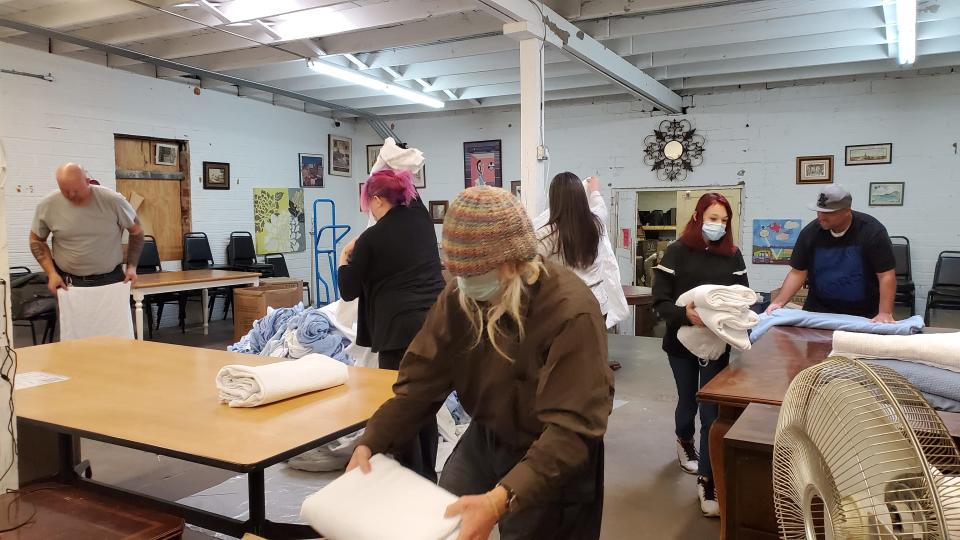 Amarillo Housing First volunteers fold blankets in the Code Blue Warming Station room for those seeking shelter against below freeing temperatures this winter season.