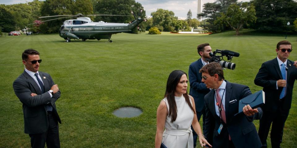 White House press secretary Stephanie Grisham, second from left, listens to deputy press secretary Hogan Gidley, as they wait for President Donald Trump to arrive to speak the media about the Congressional testimony of former special counsel Robert Mueller, Wednesday, July 24, 2019, before boarding the Marine One helicopter on the South Lawn of the White House in Washington.