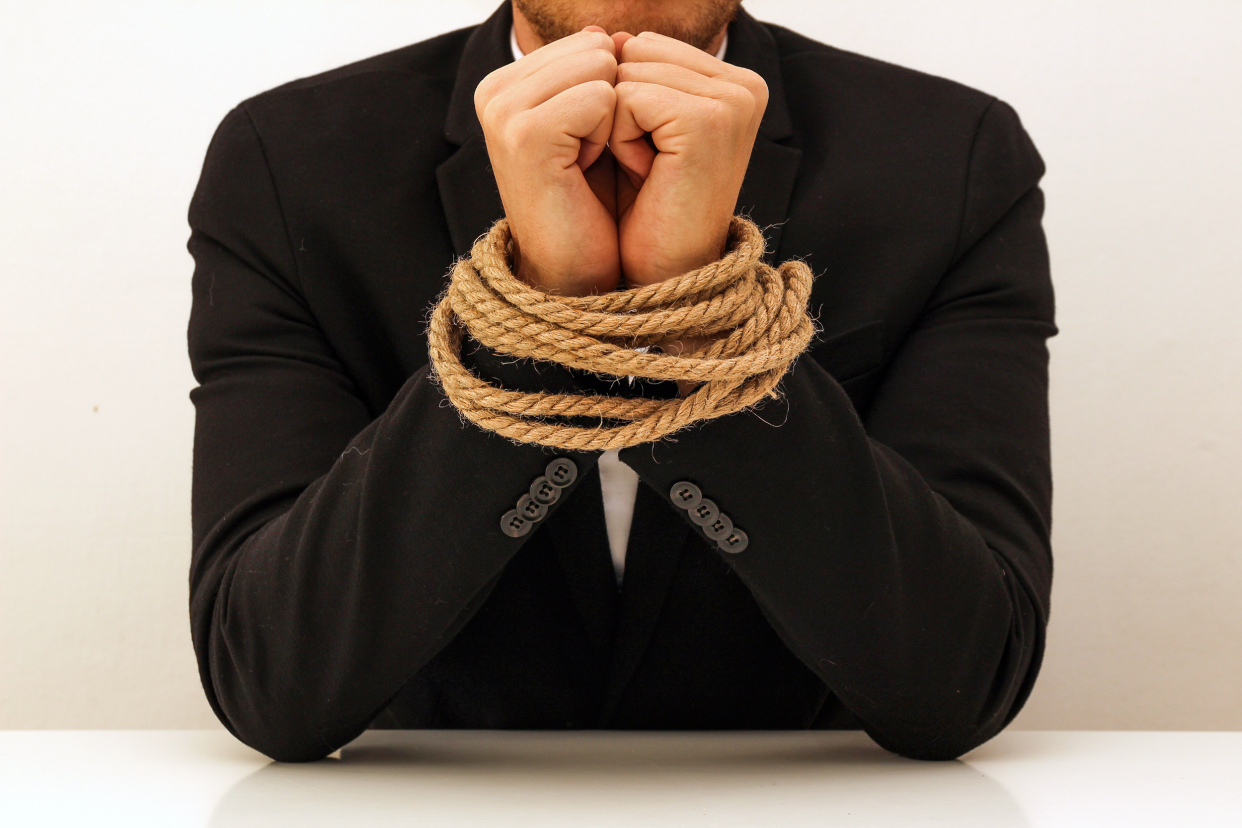 Businessman sitting with hands tied