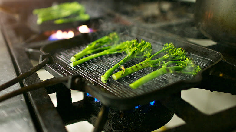 Charring broccolini in skillet over stove