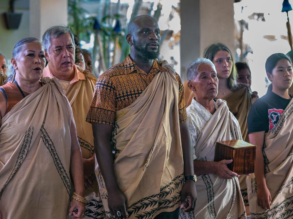 A group of people participating a cultural tradition in Hawaii.