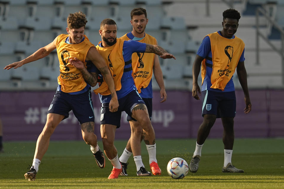 England's John Stones, front left, and Kyle Walker, front right, take part in drills during a training session at Al Wakrah Sports Complex on the eve of the Round of 16 World Cup soccer match between England and Senegal, in Al Wakarah, Qatar, Saturday, Dec. 3, 2022. (AP Photo/Abbie Parr)