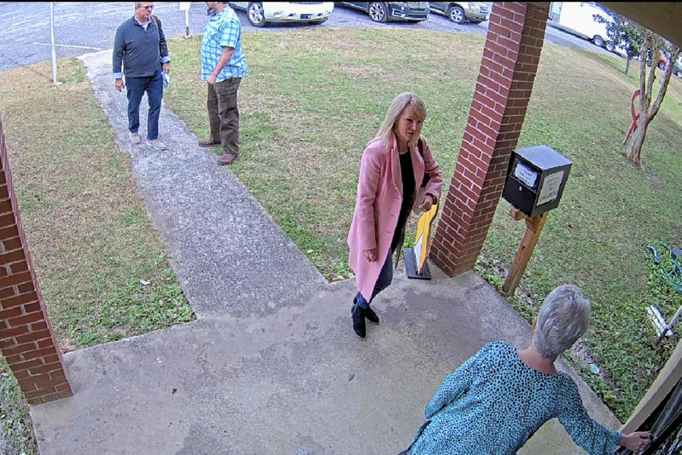 FILE - In this Jan. 7, 2021 image taken from Coffee County, Ga., security video, Cathy Latham, bottom, who was the chair of the Coffee County Republican Party at the time, greets a team of computer experts from data solutions company SullivanStrickler at the county elections office in Douglas, Ga. According to deposition testimony and documents produced in response to subpoenas, the trip to Coffee County to copy data and software from elections equipment was arranged by attorney Sidney Powell and other Trump allies. (Coffee County via AP)