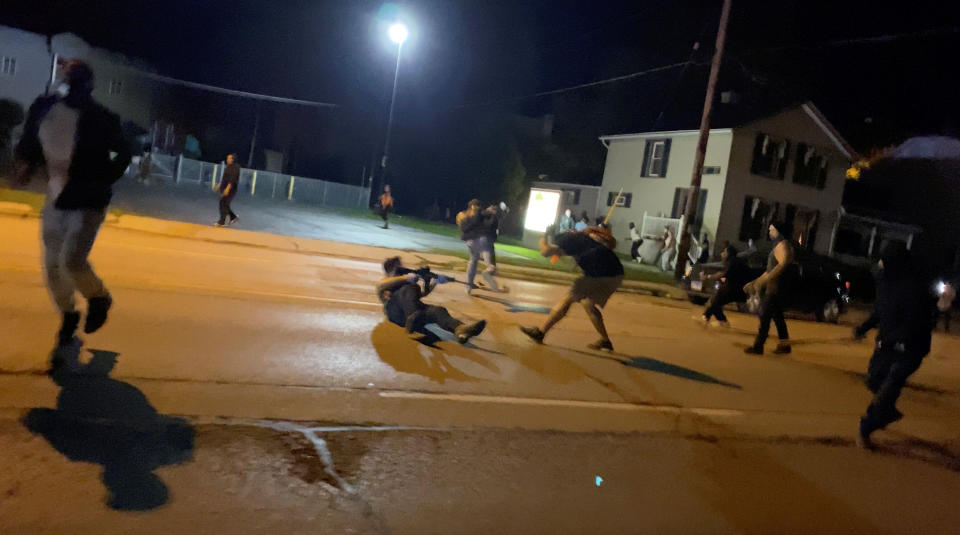 Men scuffle during a protest Tuesday following the police shooting of Jacob Blake, a Black man, in Kenosha, Wisconsin, in this still image obtained from a social media video. (Photo: Brendan Gutenschwager via REUTERS)