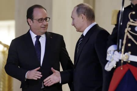 French President Francois Hollande (L) shakes hands with Russian President Vladimir Putin after a summit on the Ukraine crisis at the Elysee Palace in Paris, France, October 2, 2015. REUTERS/Philippe Wojazer