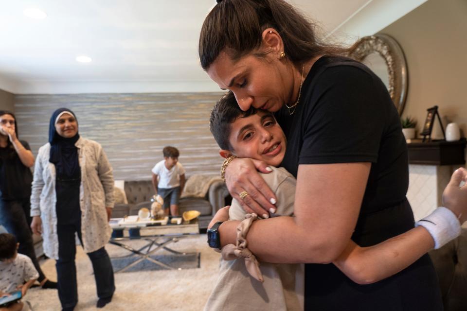 Palestine Children's Relief Fund Detroit chapter president Yasmeen Hamed, right, of Dearborn Heights, sheds a tear while hugging Saleh Humaid, 8, of Gaza, as he prepares to leave her home to return to his country after being hosted by her family on Wednesday, Aug. 9, 2023, while getting a prosthetic leg and rehabilitation in the United States.