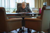 Malaysia's former Prime Minister Mahathir Mohamad reads document at his office in Kuala Lumpur, Malaysia, Friday, Aug. 19, 2022. Mahathir expects Malaysia’s graft-tainted ruling party will hold general elections in coming months, and could win big, but the nonagenarian reformer vowed Friday that he would fight "even a losing battle" on principle. (AP Photo/Vincent Thian)