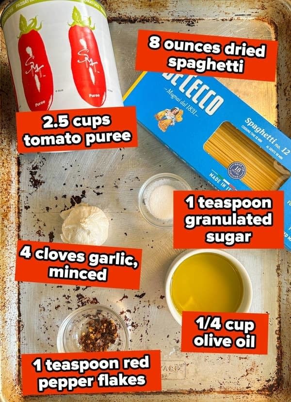 Ingredients for a recipe laid out: pasta, tomato puree, garlic, spices, and olive oil