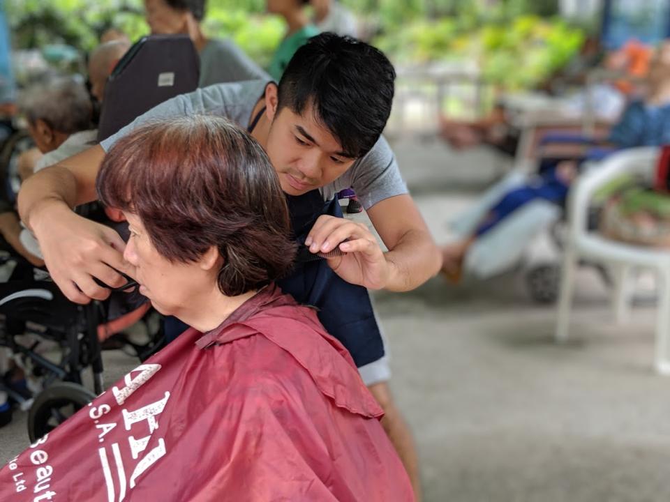 Founder <span>Cai Yinzhou giving a haircut at </span>Green Avenue Home for the Elderly on 19 January, 2019. (PHOTO: Geylang Adventures)