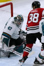 San Jose Sharks goaltender James Reimer, left, makes a save on a shot by Chicago Blackhawks left wing Brandon Hagel during the first period of an NHL hockey game in Chicago, Sunday, Nov. 28, 2021. (AP Photo/Nam Y. Huh)