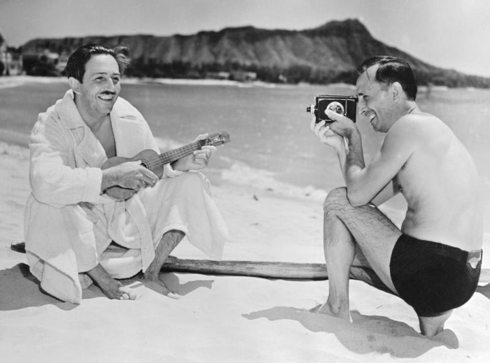 <div class="inline-image__caption"><p>Walt Disney is shown on the beach at Waikiki playing on a ukulele, while his brother and business manager, Roy, makes him the subject of a movie.</p></div> <div class="inline-image__credit">Bettmann/Getty</div>