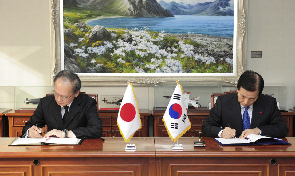 FILE - In this Nov. 23, 2016, file photo provided by South Korean Defense Ministry, South Korean Defense Minister Han Min Koo, right, and Japanese Ambassador to South Korea Yasumasa Nagamine sign the General Security of Military Information Agreement, or GSOMIA, an intelligence-sharing agreement between South Korea and Japan in Seoul, South Korea. South Korea has threatened to end the military intelligence sharing agreement with Japan as their tensions escalate over export controls. The agreement, known as GSOMIA, is a symbol of the countries’ trilateral security cooperation with their ally United States in the region. (South Korean Defense Ministry via AP, File)