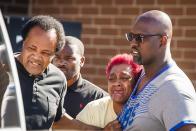 A woman crying is escorted by community activists, including Andrew Holmes, left,, to a vehicle after she tried to cross police tape at the scene of a shooting outside a home in Chicago, Tuesday, June 15, 2021. Police say an argument at a house on Chicago's South Side erupted in fatal gunfire, leaving some dead and others injured.